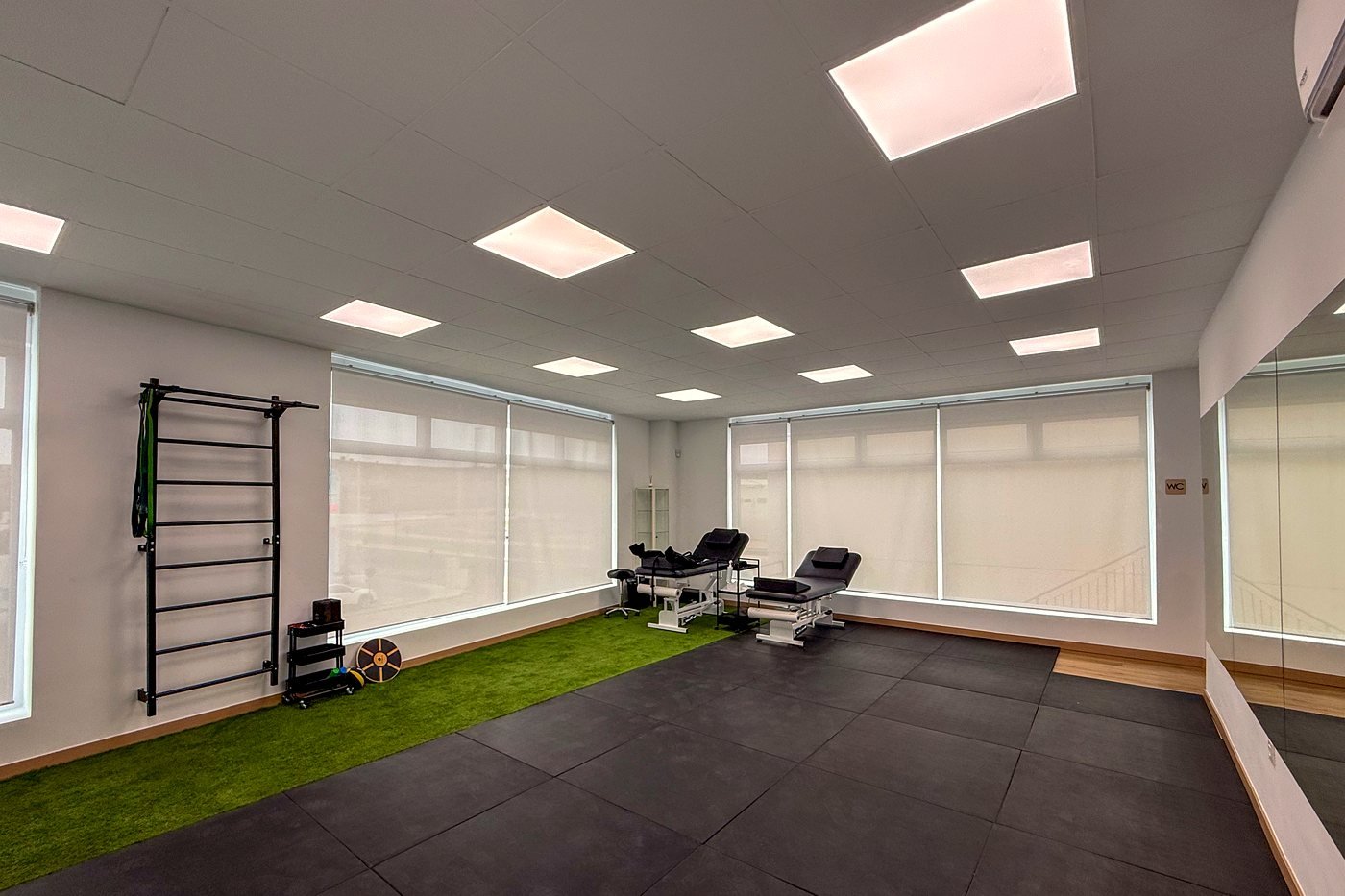 Sala de fisioterapia de Clínica Apolo con camillas, espaldera y zona de ejercicio terapéutico